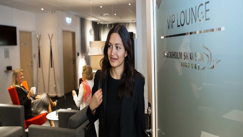 Människor i en lounge med en kvinna i förgrunden Människor i en lounge med en kvinna i förgrunden