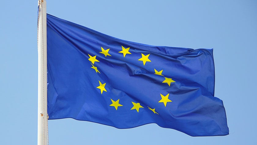 Eu-flagga (blå bakgrund och gula stjärnor i en cirkel) vajar i vinden