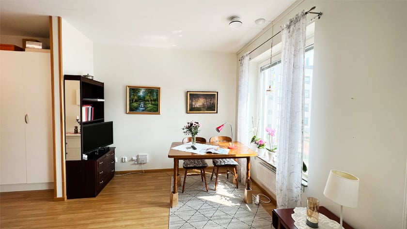 En del av ett rum med köksbord och stolar vid ett fönster i en lägenhet på boendet