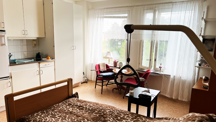 Ett rum i en lägenhet med säng, bord och stolar och pentry, på Mariebergsgården