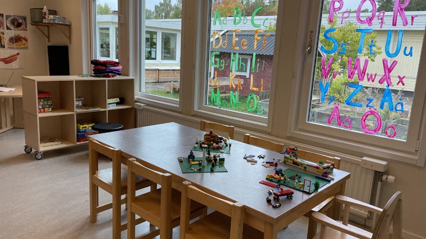 Ett av förskolans rum med lego på bordet och målade bokstäver på fönstren