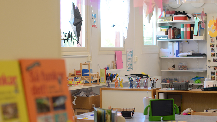 Bild inifrån ett av rummen på förskola, med böcker och pennor