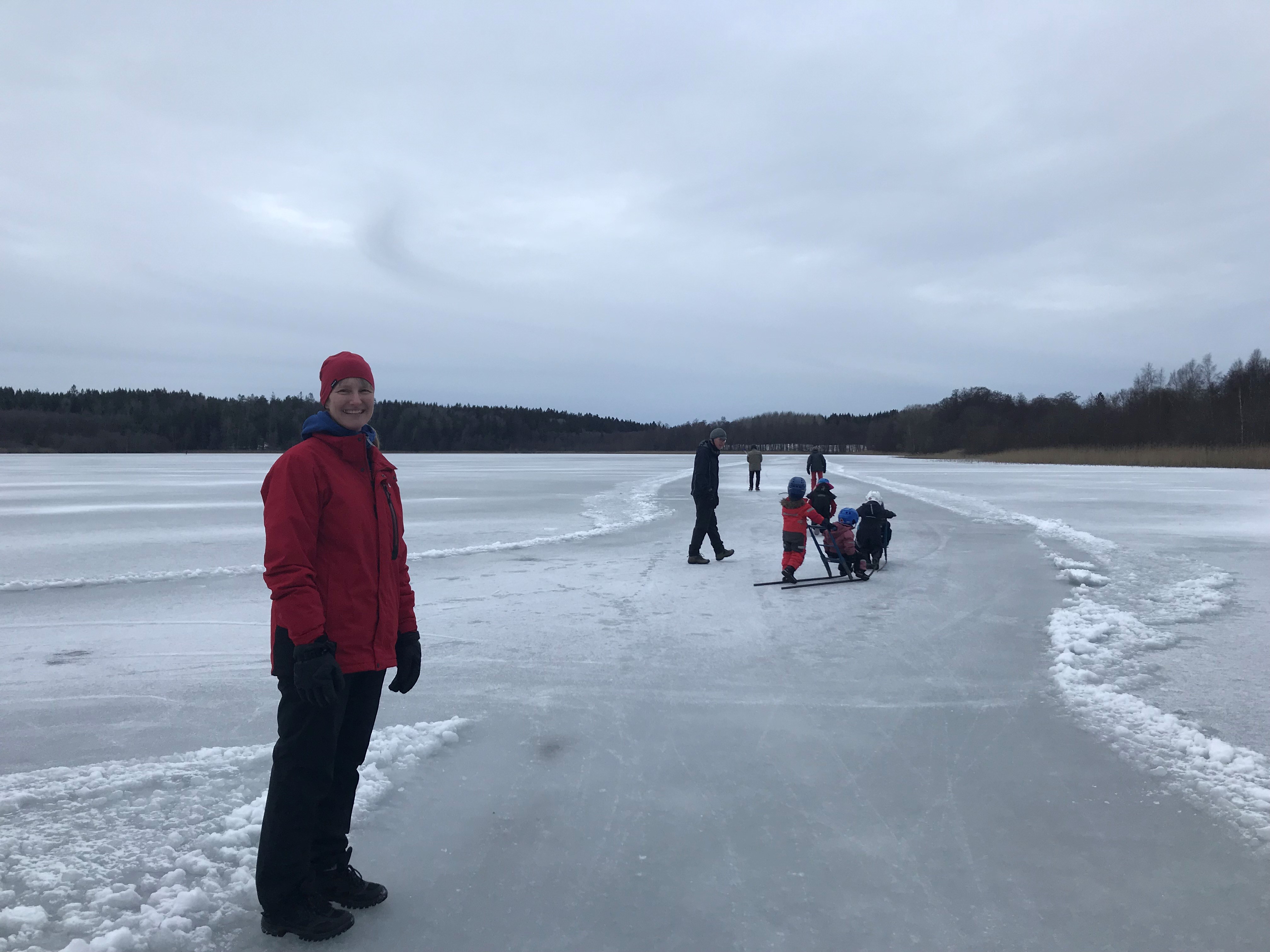 Pedagog och barn med spark som leker på isen