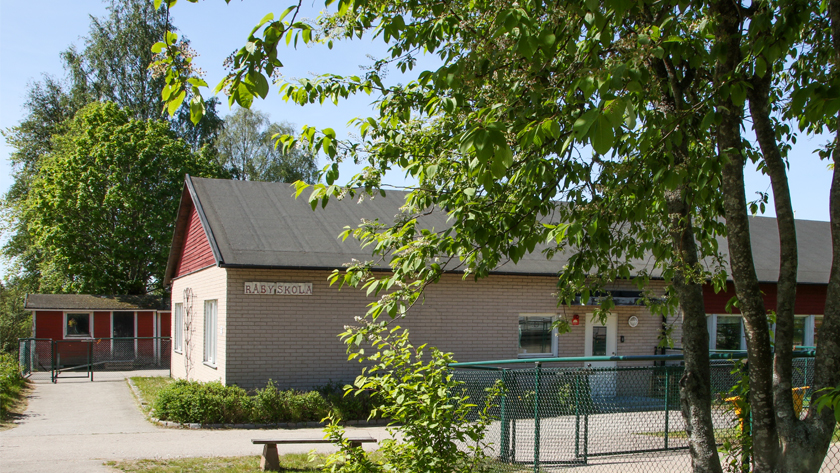 Foto på gul låg tegelbyggnad som är Råby skola