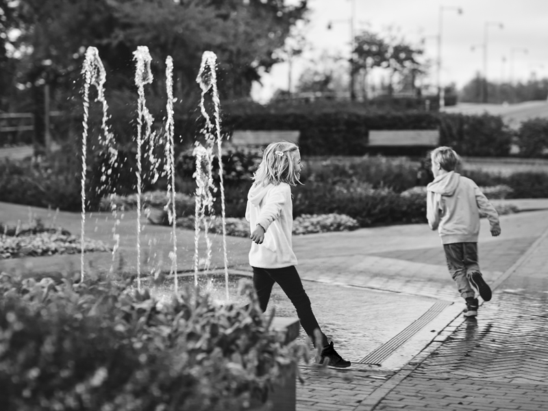 Maja och Fille springer i fontänen vid Teatertorget