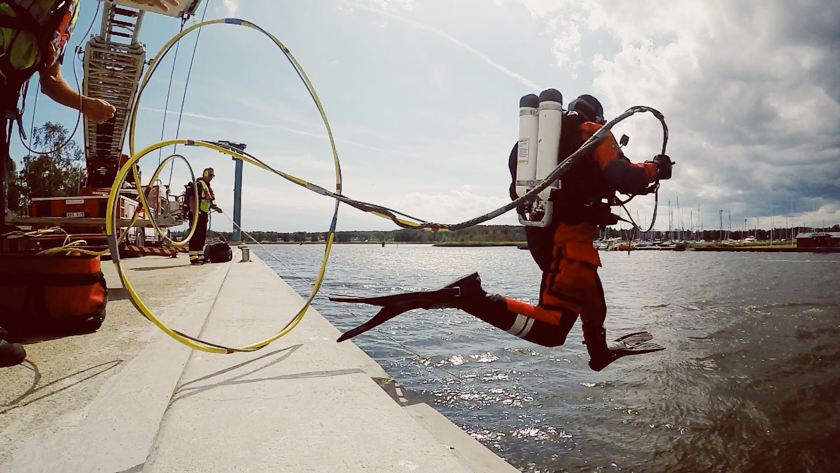 En räddningsdykare hoppar ner i vattnet