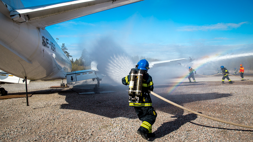 Brandman släcker en brand på ett flygplan utomhus